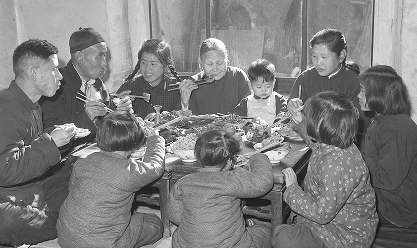 1953年春節(jié)天津漢沽區(qū)蘆臺(tái)王德鑄(左一)一家人吃團(tuán)圓飯(新華社稿)